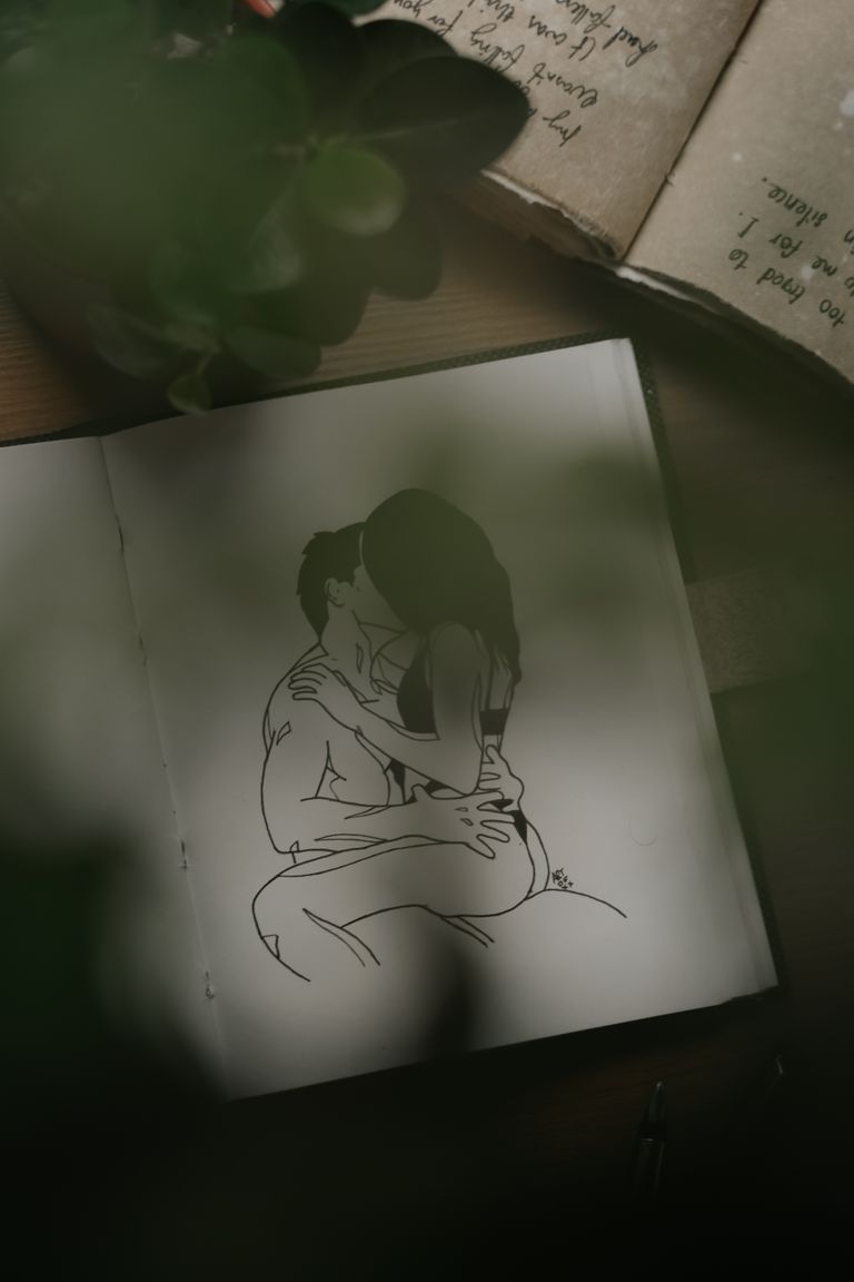 A close-up image showing a romantic drawing of a couple embracing, captured in a dimly lit setting.