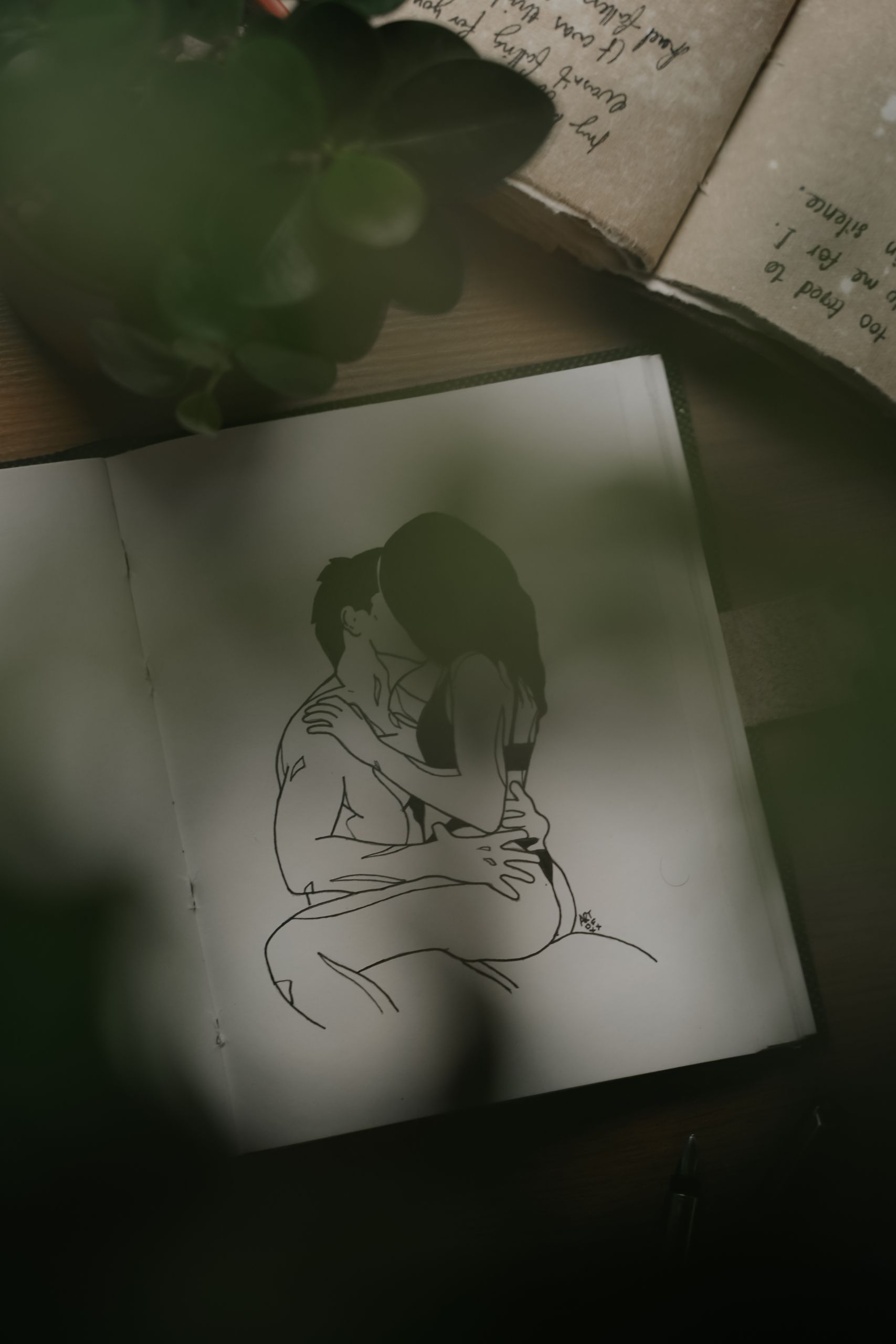 A close-up image showing a romantic drawing of a couple embracing, captured in a dimly lit setting.