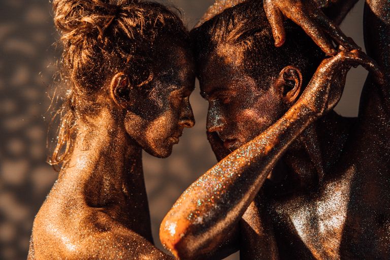 A conceptual portrait of a couple covered in glitter, symbolizing intimacy and art.