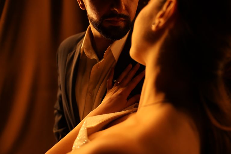 Un couple enlacé avec chaleur et intimité, saisi dans une lumière douce évoquant le romantisme.