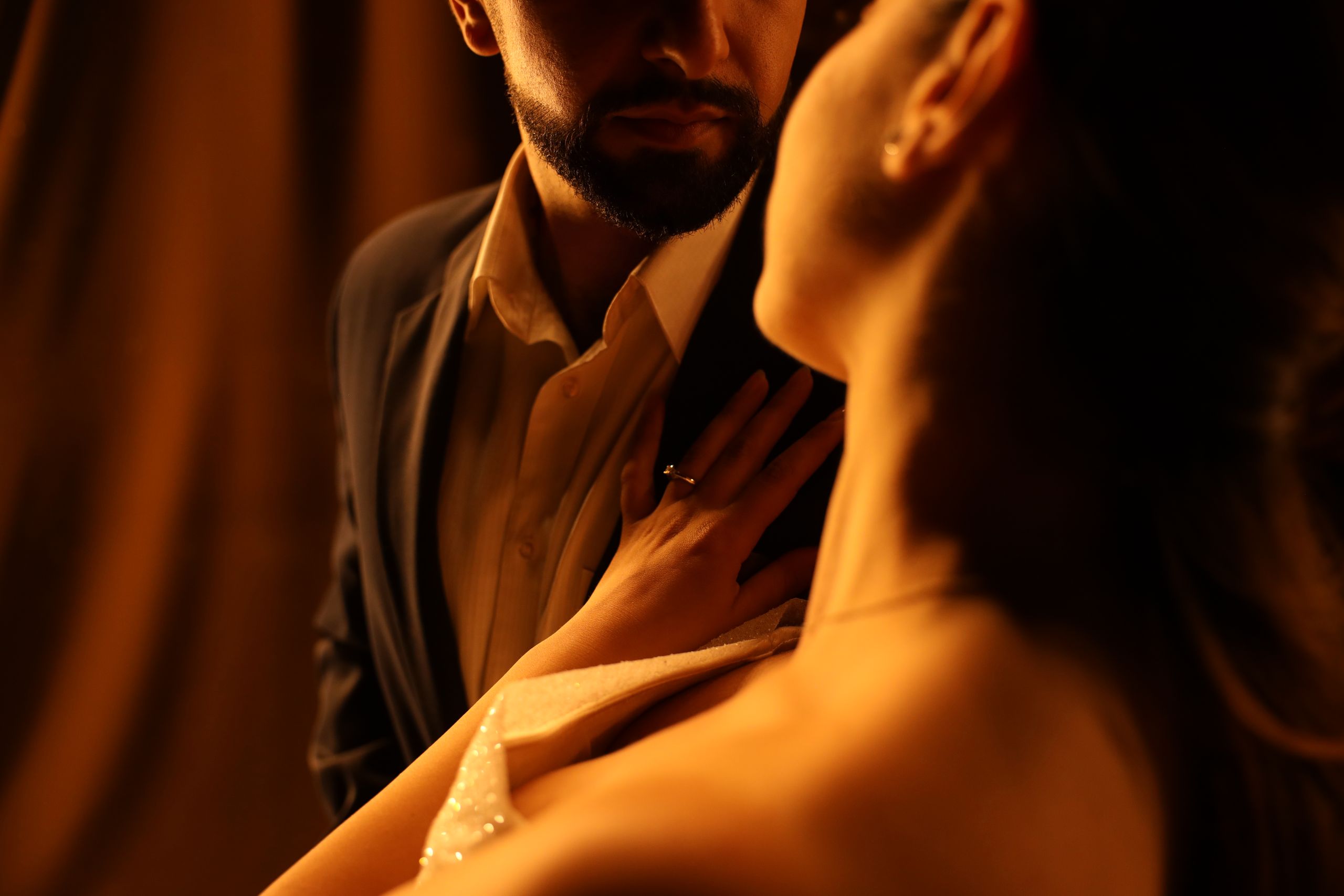 Un couple enlacé avec chaleur et intimité, saisi dans une lumière douce évoquant le romantisme.