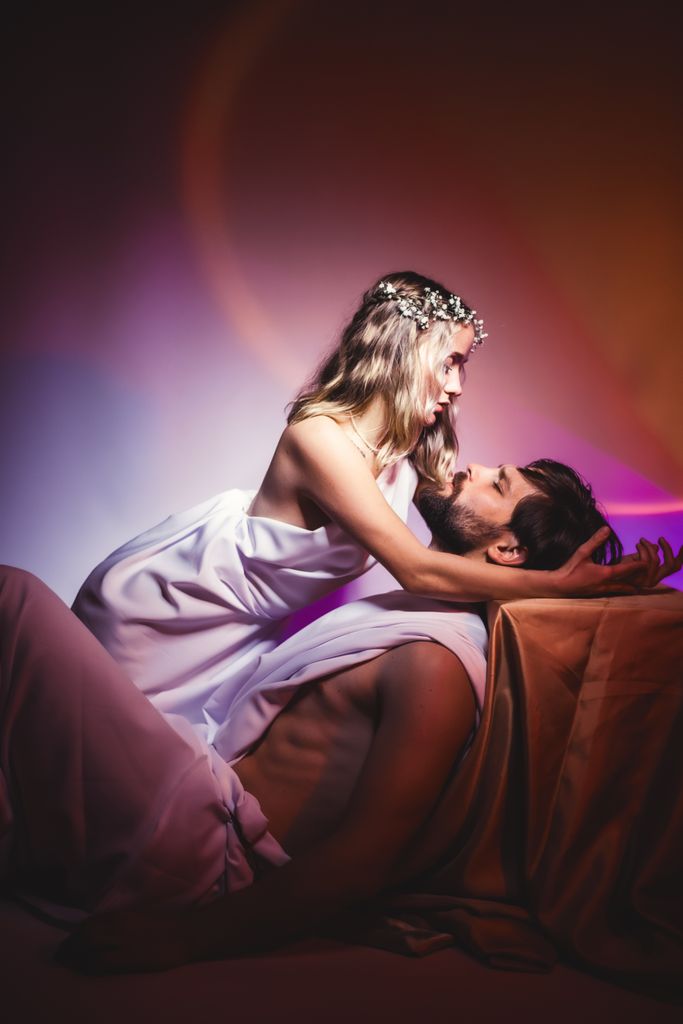 A romantic couple posing passionately with dramatic lighting and soft textures, conveying intimacy and connection.